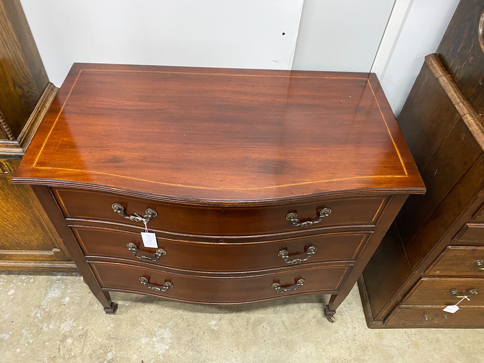 An Edwardian satinwood banded serpentine front inlaid mahogany three drawer chest, width 91cm, depth 51cm, height 84cm